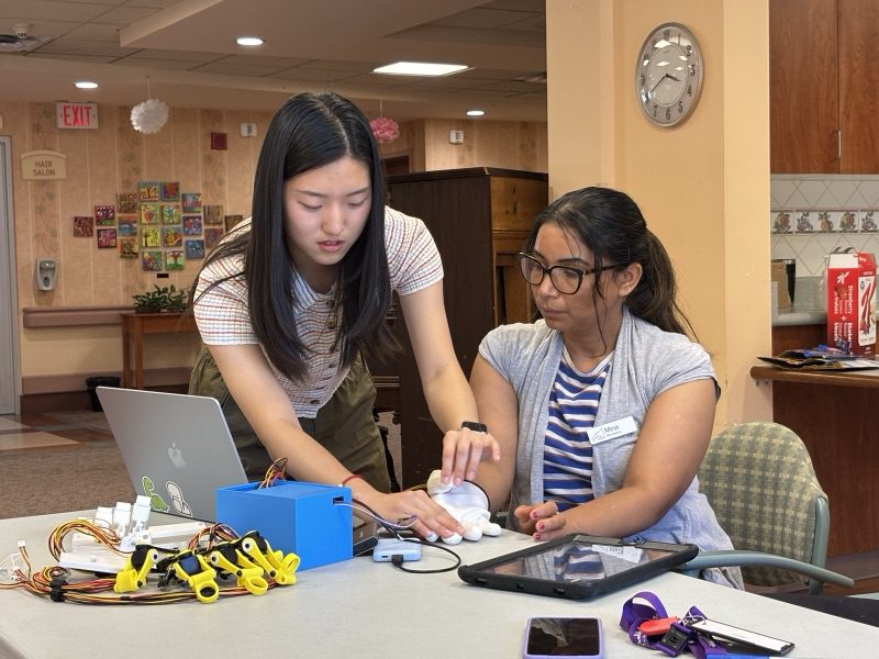 Yanzi walking a staff member through the device and app at a table